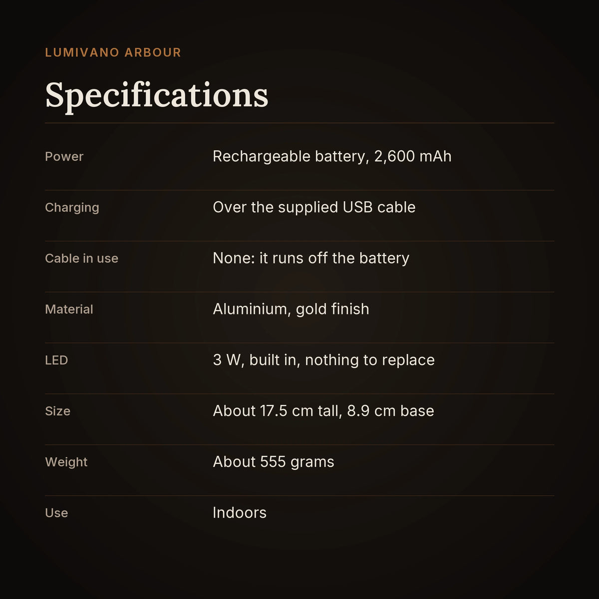 A specification card on the dark brand ground: a 2,600 mAh rechargeable battery charged over the supplied USB cable, no cable in use, aluminium in a gold finish, a built-in 3 watt LED, about 17.5 cm tall with an 8.9 cm base, about 555 grams, and indoor use.