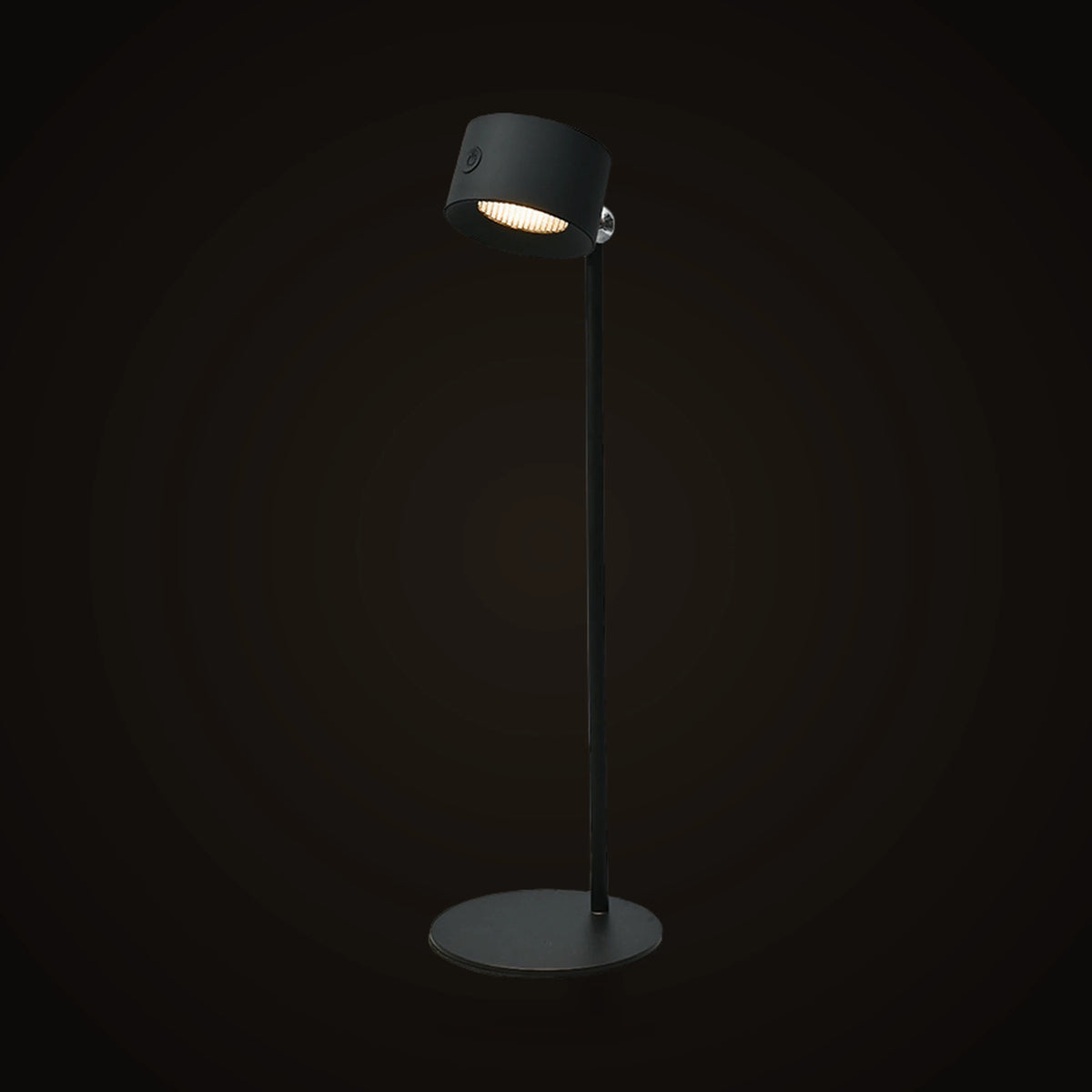 The Lumivano Halo on the dark brand ground: a black cordless table lamp with a round base, a slim stem and a tilting cylinder head.