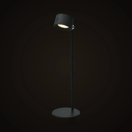 The Lumivano Halo on the dark brand ground: a black cordless table lamp with a round base, a slim stem and a tilting cylinder head.