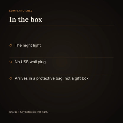 An in-the-box card on the dark brand ground listing the night light, no USB wall plug, and that it arrives in a protective bag rather than a gift box, with a note to charge it fully before its first night.