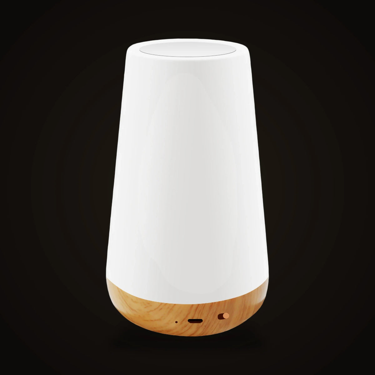 The Lumivano Thimble switched off, on the dark brand ground: a small tapered drum-shaped lamp with a smooth white shade and a flat round top with a pale inset disc, over a rounded base with a light honey-coloured wood-grain finish that has a small charging port, a pinhole and a small slide switch on the front.